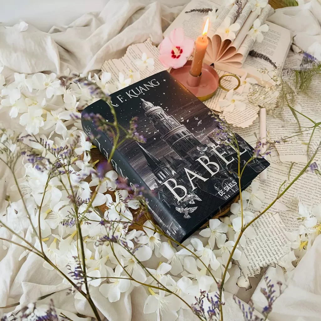 Couverture du roman Babel de R. F. Kuang posée sur des fleurs blanches